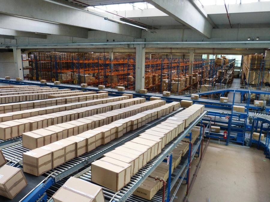 Cartons moving along parallel conveyor lines inside a distribution warehouse